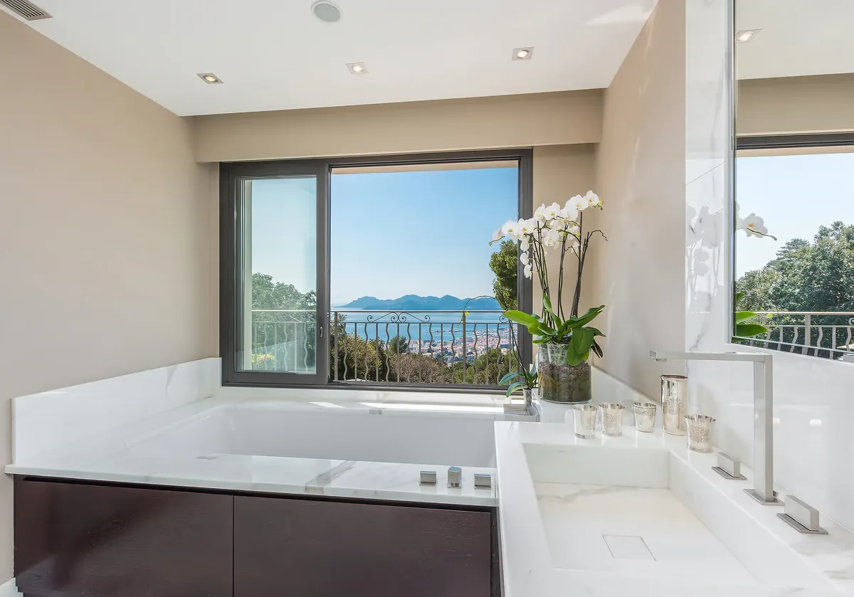 Salle de bain maître avec baignoire encastrée et vue mer
