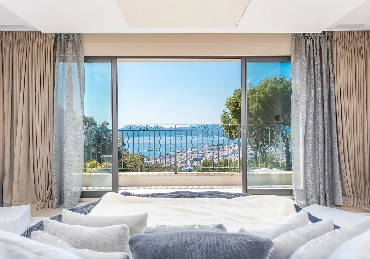 Salon TV avec baie vitrée et vue panoramique sur la baie de Cannes