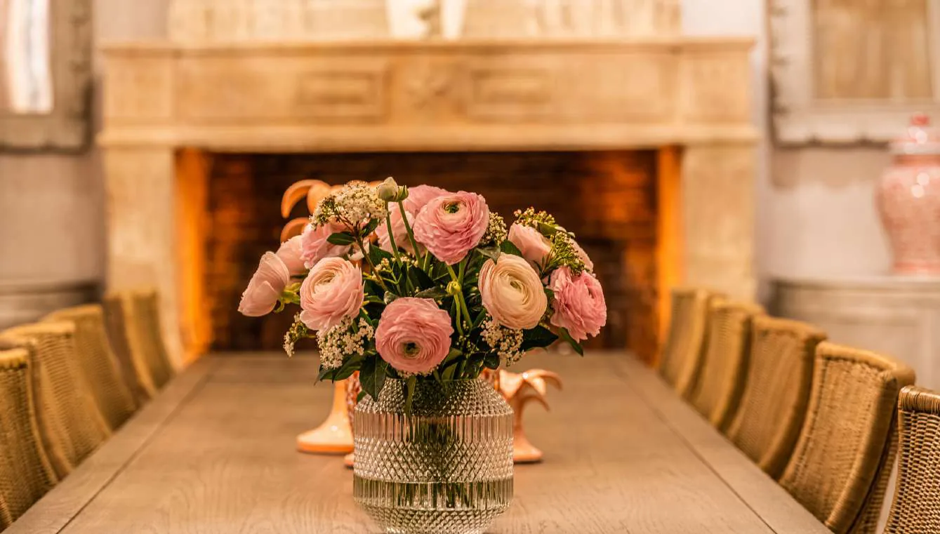 Detail de la cheminee historique avec vases roses et palmiers ceramique