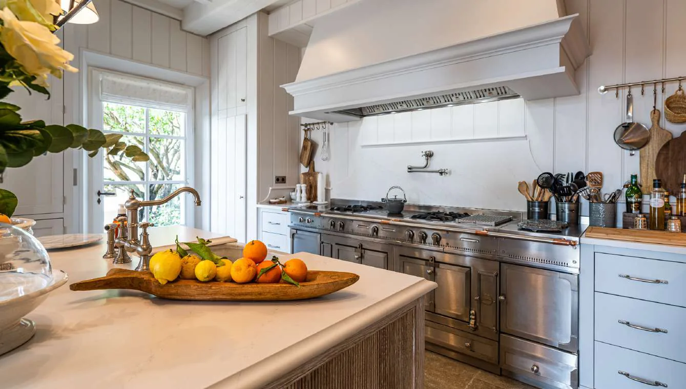 Cuisine principale avec ilot bois, suspensions et pianos La Cornue inox