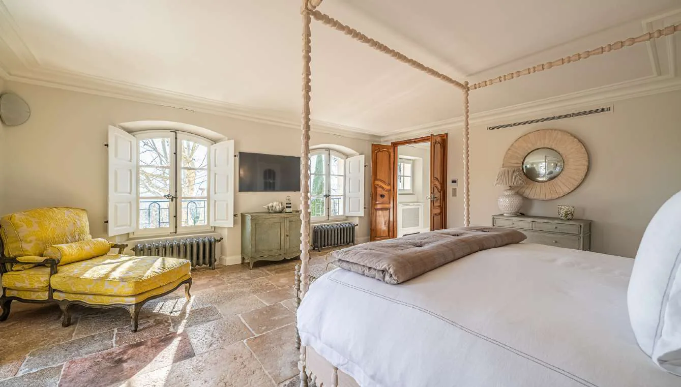 Salle media avec grand canape gris, TV mural et parquet ancien