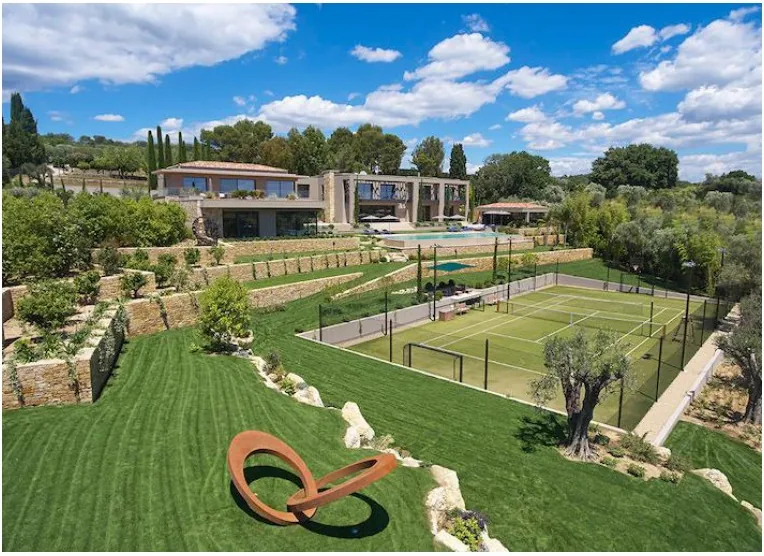 Vue aérienne : villa, piscine, jardins paysagés et court multisport