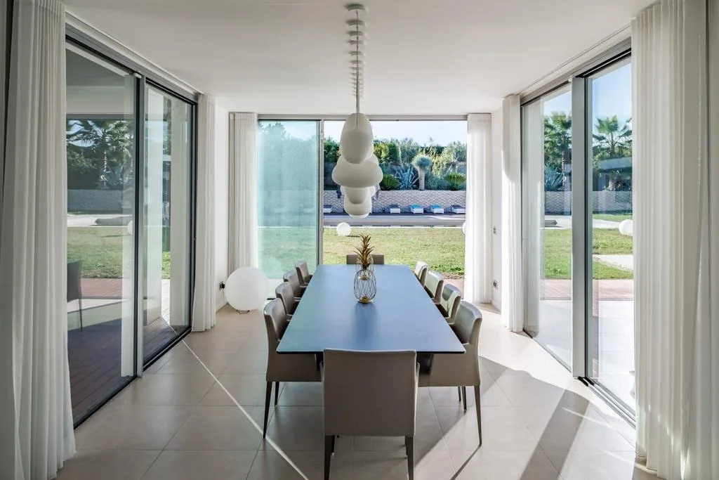 Salle à manger entourée de baies vitrées